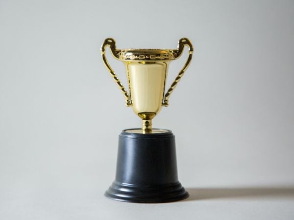 Ein goldener Pokal auf einem schwarzen Podest.