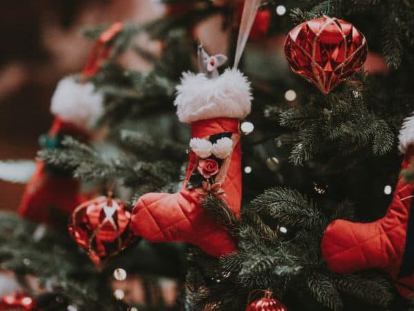 An einem Tannenbaum hängt Weihnachtsschmuck.